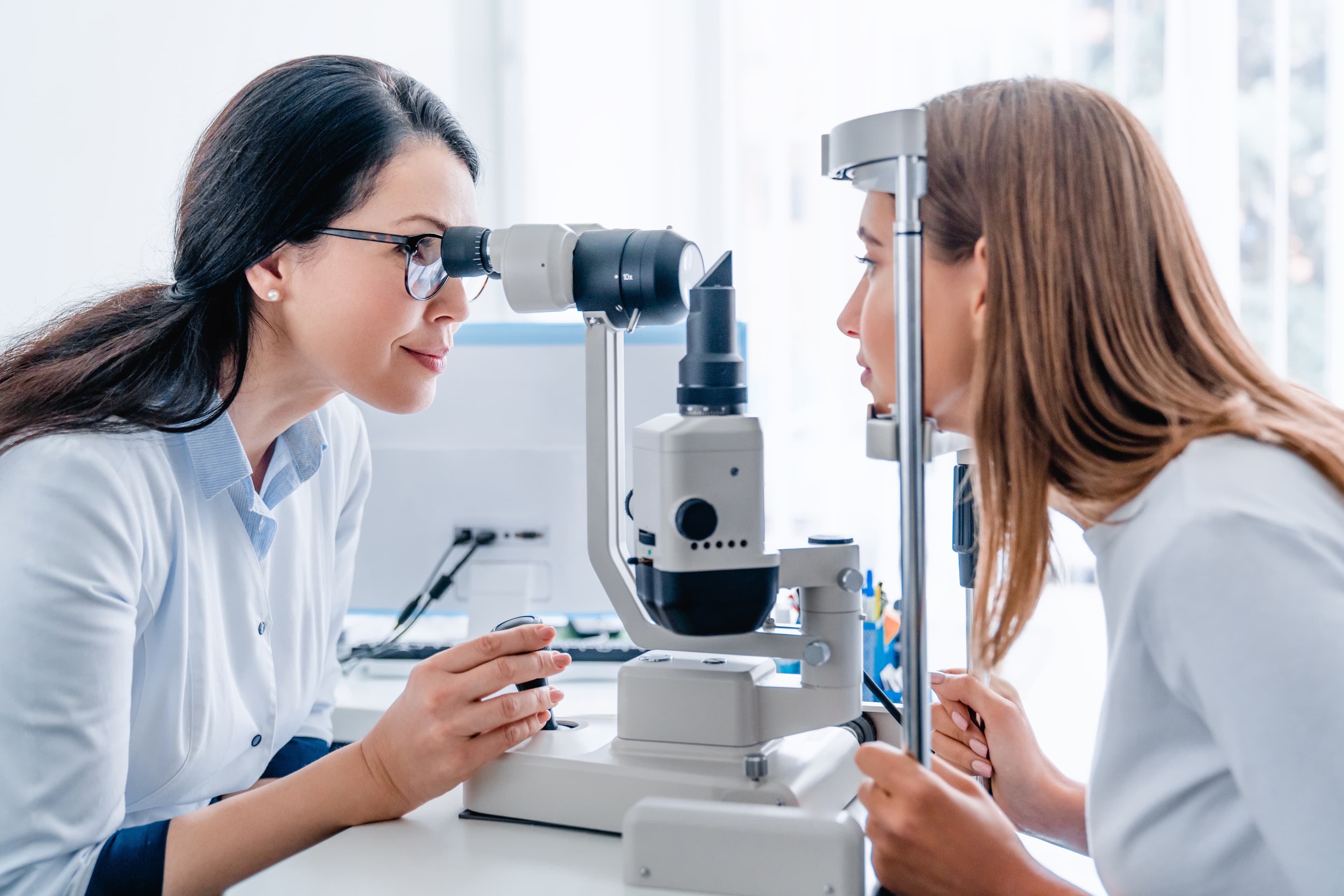Eye care professional using a microscope